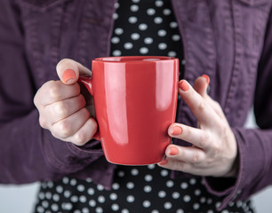 A woman holding red mug