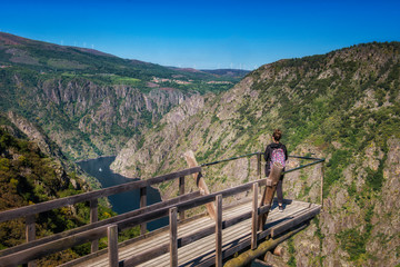 Fototapeta na wymiar a woman contemplates the incredible Sil Canyon in the Ribeira Sacra from a fabulous viewpoint