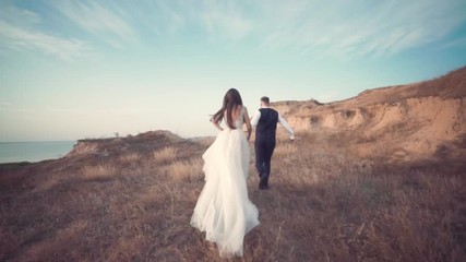 Romantic wedding moment, couple of bride and groom hug while on a walk in the park. Loving wedding couple outdoor. - Powered by Adobe