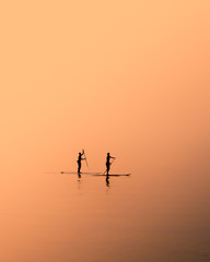 Fototapeta na wymiar paddle boarding at dawn