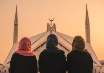 women in front of mosque - obrazy, fototapety, plakaty