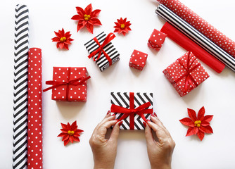 Obraz premium The process of packaging Christmas gifts. Poinsettia. New Year.
