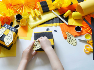 The child loves crafts bee. The child's hands. Gift packing. Materials for creativity.