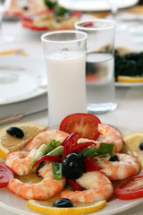 Shrimps with tomatoes and raki on the restaurant table 