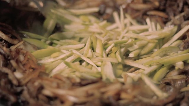 Mixing chopped and chopped vegetables on hot plate