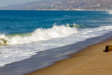 pacific ocean crashing along sandy bright shoreline