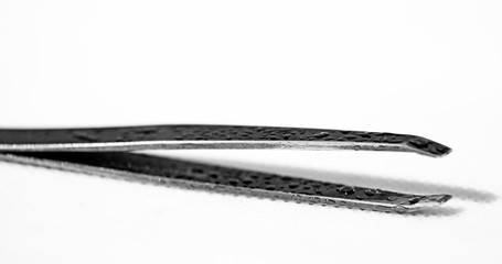 a pair of tweezers in metal