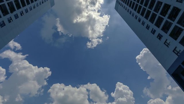 Color Time Lapse of Residential Architecture 4k Color Time Lapse from low angle looking up to dramatic clouds moving upward through the scene. Sun is flaring into the lens.