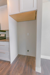 Interior of a kitchen with hanging cabinet above the empty refrigerator alcove