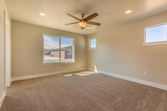 Empty room of a new house with beige wall paint and carpeted floor