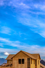 Exterior of a house under construction against vivid blue sky with clouds