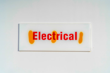 Close up of an electrical sign board against a white wall