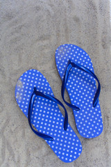 Blue flip flops on a sandy beach. View from the top