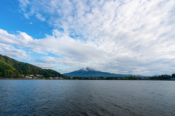 Beautiful Fuji Mountain, Fujisan volcano at Kawaguchiko lake, Japan. Blue sky high peak mountains fog hills mist scenery river lake 