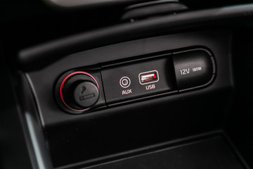 Сlose-up of the car  black interior:  power outlet 12V, USB, AUX and other buttons.