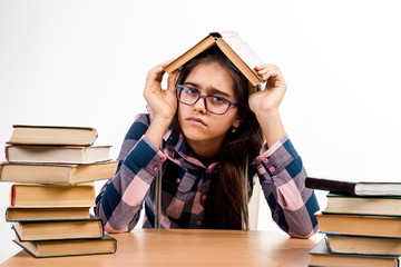 girl with books. girl in glasses with a book on her head. Horror exams. Graduation final Exams at school. Education. Printed books, study at school. Library. Girl with books. 