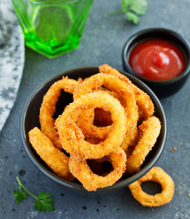 Homemade crunchy fried onion rings with tomato sauce
