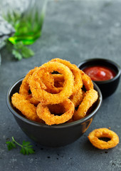 Homemade crunchy fried onion rings with tomato sauce
