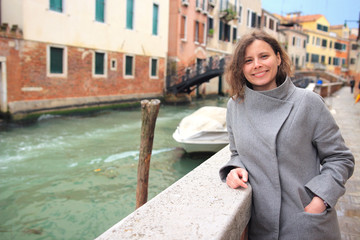 Fototapeta na wymiar Woman in Venice, Italy. Girl posing on venetian canal background. Attractive woman in Venezia