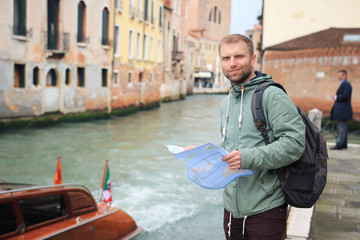 Fototapeta na wymiar Man with city map in Venice, Italy. Young guy in Venice. Walking to venetian streets and canals