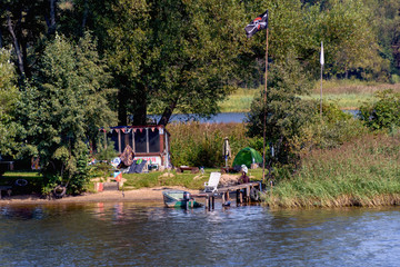 Hiking camp on the river bank. Tourism and outdoor recreation in the forest on the banks of the river. Ecology. Russia, Moscow region, August 2108.
