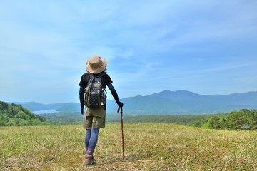 高原のトレッキング・草原を歩く女性
