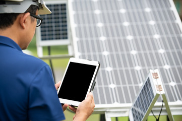 An engineer with tablet computer on a background of photovoltaic panels.