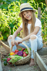 A child with vegetables in the garden. 