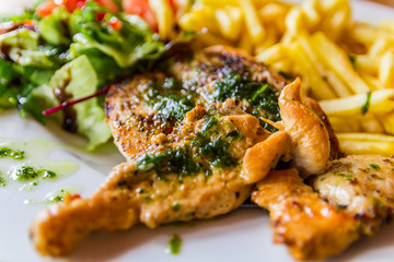 Grilled chicken steak seved with vegetables and potato chips