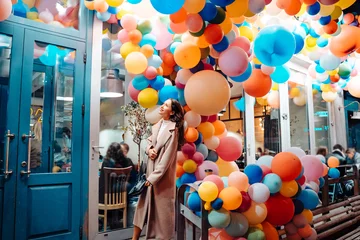 Tuinposter Woman on the background of wooden door with balloons © teksomolika