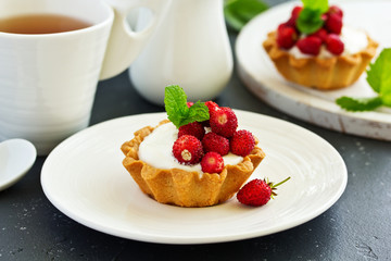 Wild strawberry tartlets with cream filling. delicious summer fruit mini tarts