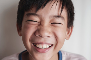 Portrait of happy Asian tween preteen boy laughing © SewcreamStudio