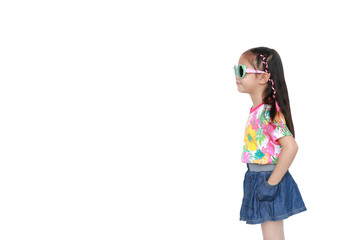 Beautiful little Asian kid girl wearing a flowers summer dress and sunglasses isolated on white background with copy space. Summer and fashion concept. Side view.