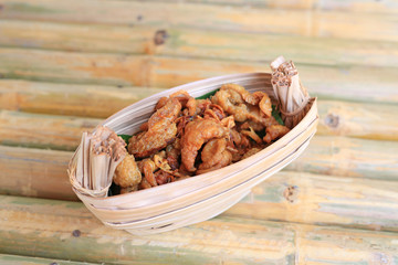 Crispy Fried Chicken Skins served on dry leaves bowl.