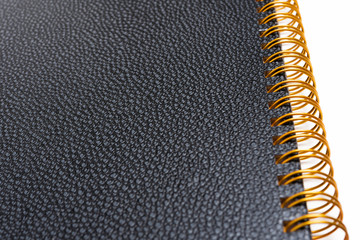 An elegant spiral-bound notebook or journal with elegant textured faux leather hard cover artfully...
