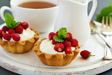 Wild strawberry tartlets with cream filling. delicious summer fruit mini tarts
