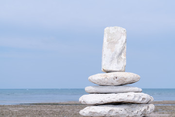Pyramid of stones standing in beach water real natural blurred background