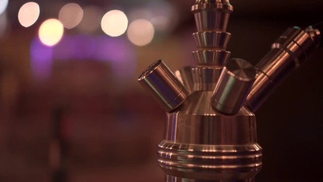 Vaporizing toxic smoke of hookah sheesha instrument, rack focus shot