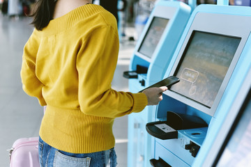 Traveler using a self check-in machine kiosk service at airport, Technology and smart application...