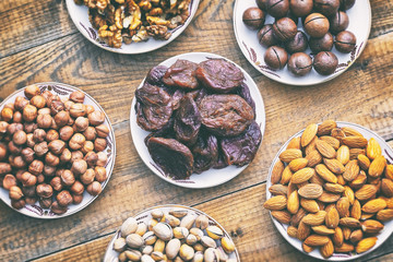 assorted nuts and dried apricots on a wooden background