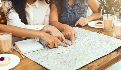 Fototapeta na wymiar Three women exploring map, deciding where to travel this summer