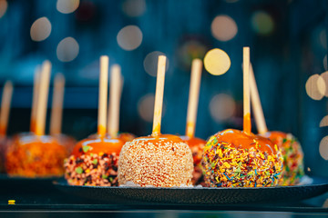 Apples in caramel and sprinkles. Street food.