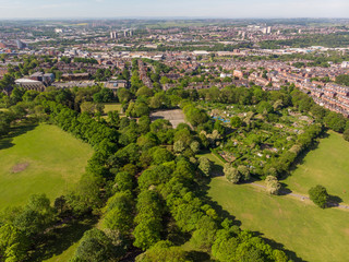 Obraz premium Aerial footage of the Leeds town of Headingley, the footage shows Terrence houses and homes and the town centre in the background with roads and traffic, taken on a beautiful sunny day.