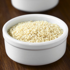 White sesame seeds in small bowl, photographed with natural light (Selective Focus, Focus one third into the seeds)