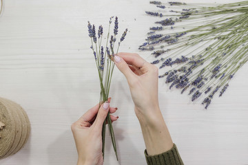 Young female flower seller laughs making up a flower arrangement. Flower shop. A smiling woman cut...
