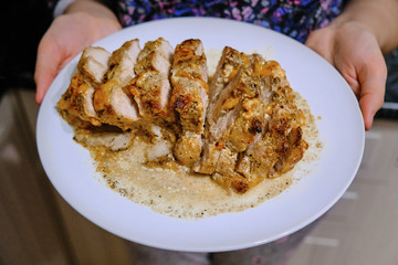 Big plate of meat. Sliced beef without bone. A huge piece of baked meat. Girl holding a plate of food. Women's hands and a plate of broth.