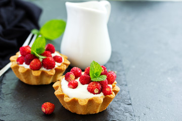 Wild strawberry tartlets with cream filling. delicious summer fruit mini tarts