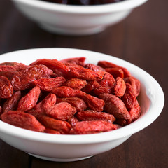 Dried gojis or wolfberries in small bowl, photographed with natural light (Selective Focus, Focus on the berries in the middle of the bowl)