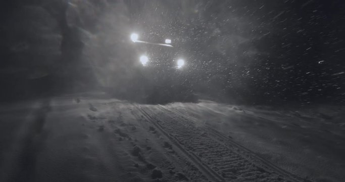 Half-track driving in the night in Jotunheimen in Norway. The half-track has skies in front. Its night and the snow are falling. Filmed on a gimbal in 4k. This is a slow-motion clip.