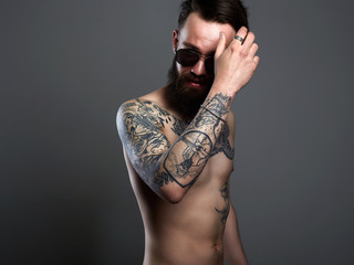 Bearded Man in sunglasses, naked tattoed young male body